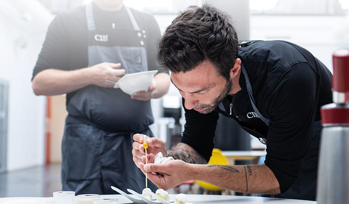 Chef cooking with in the Advanced Culinary Technique Course