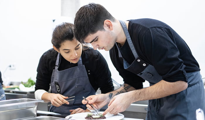 Estudiant per ser xef cuinant un plat de d'alta cuina